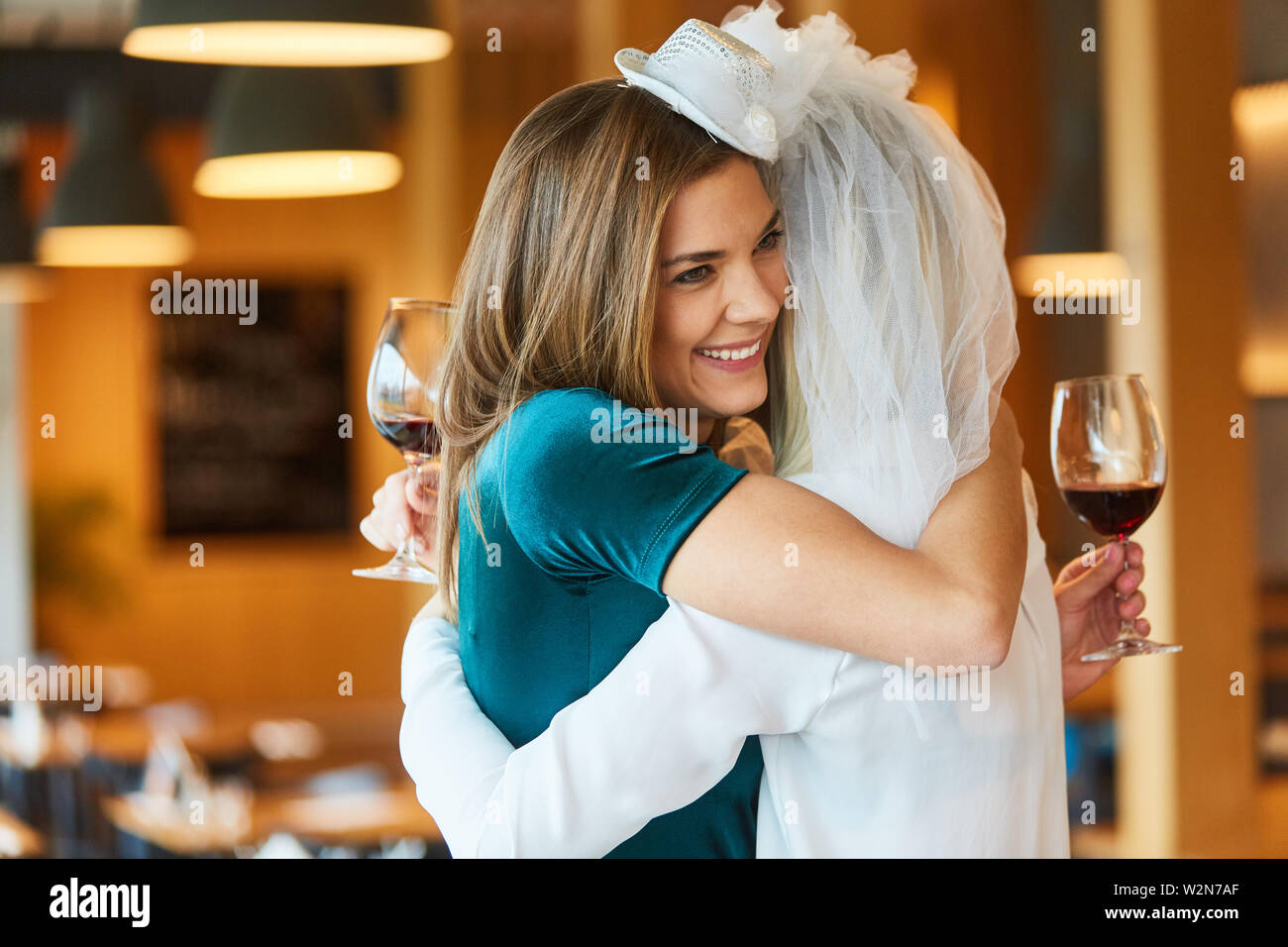 Braut umarmt sie bester Freund bei Polterabend im Restaurant Stockfoto