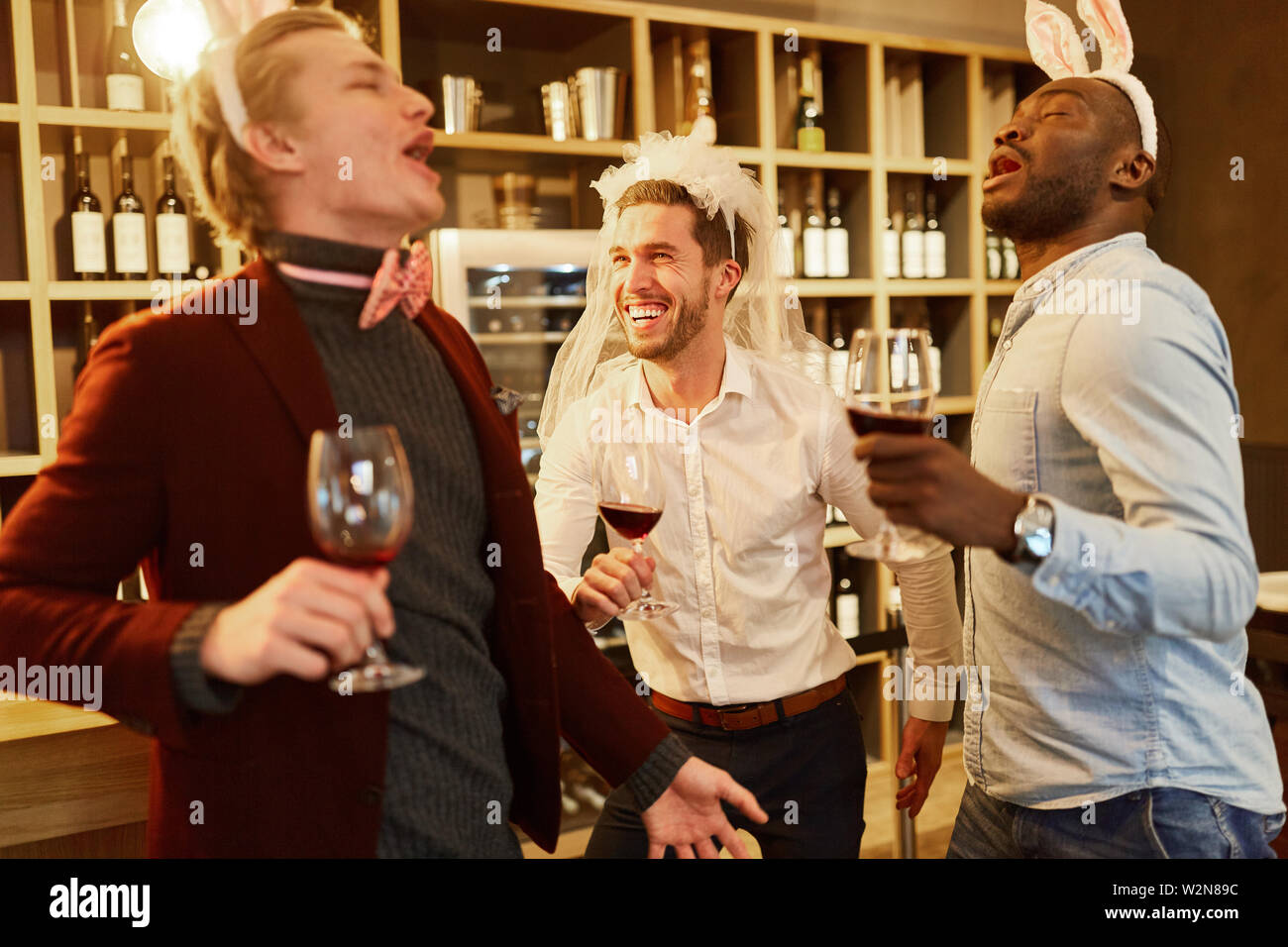 Freunde feiern urkomisch und getrunken, Junggesellenabschied in einer Bar Stockfoto