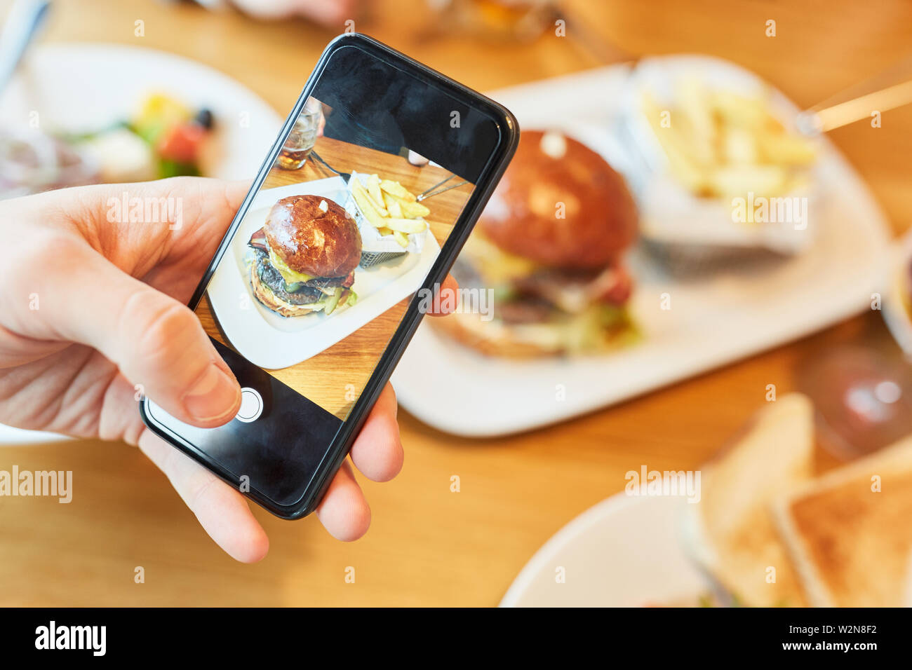 Hamburger Erzähler ist mit einem Smartphone für ein Essen blog fotografiert. Stockfoto