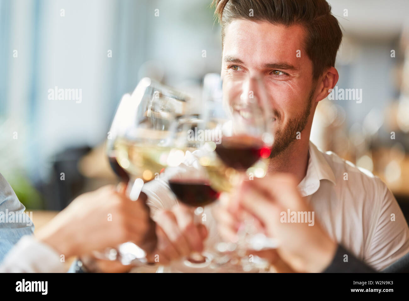 Man Toasten mit einem Glas Wein bei einer Feier im Restaurant Stockfoto