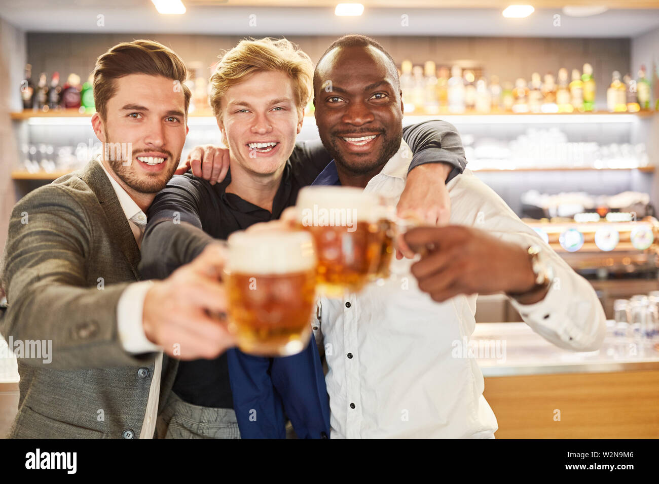 Drei Freunde trinken Bier zusammen und in einer Bar oder einem Pub feiern Stockfoto