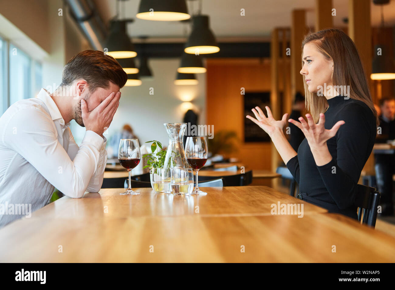 Junge Paare streiten und diskutieren im Restaurant bei einem Glas Wein Stockfoto