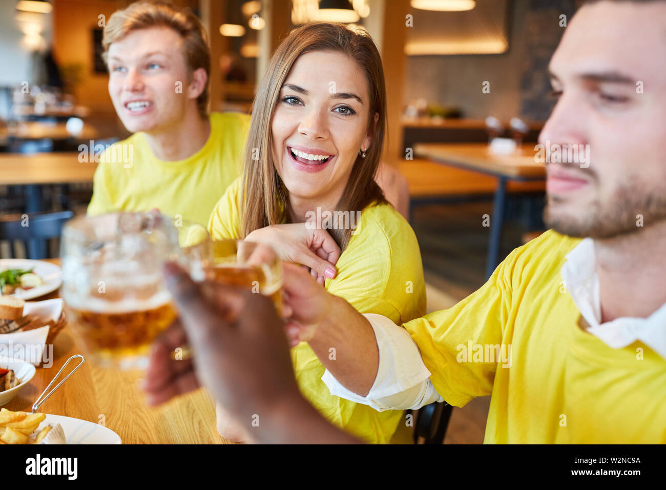 Freunde und Fans von einem Team beim Feiern und trinken Bier in einem Pub Stockfoto