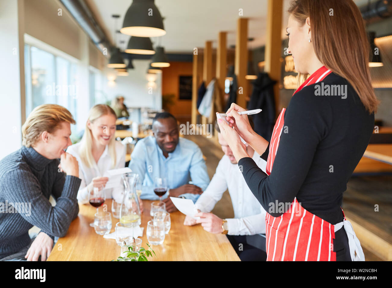 Kellnerin mit Notepad im Restaurant wartet auf die Reihenfolge der Gäste Stockfoto