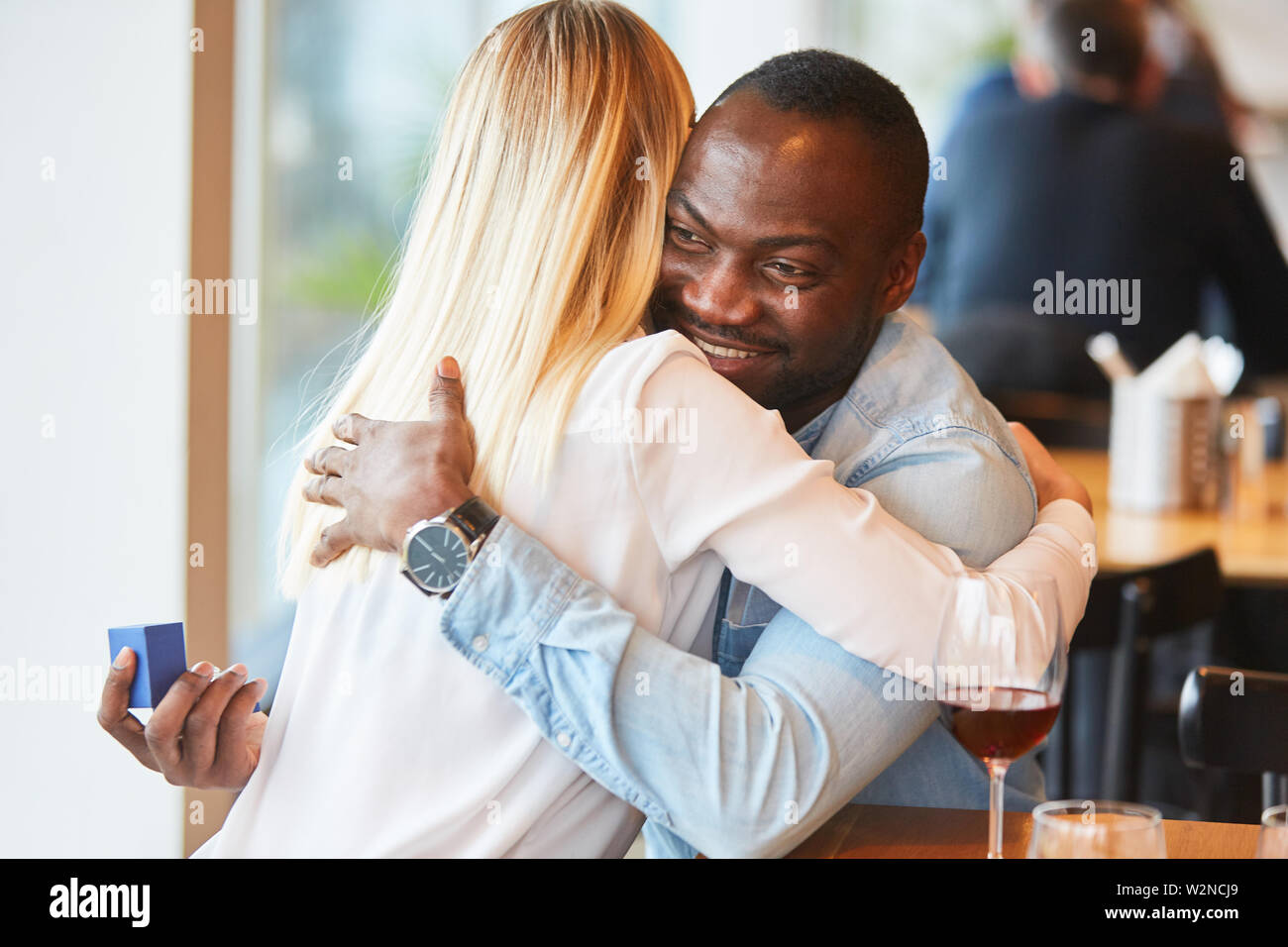 Fröhlich multikulturellen Paar umarmen einander beim Dating im Restaurant Stockfoto