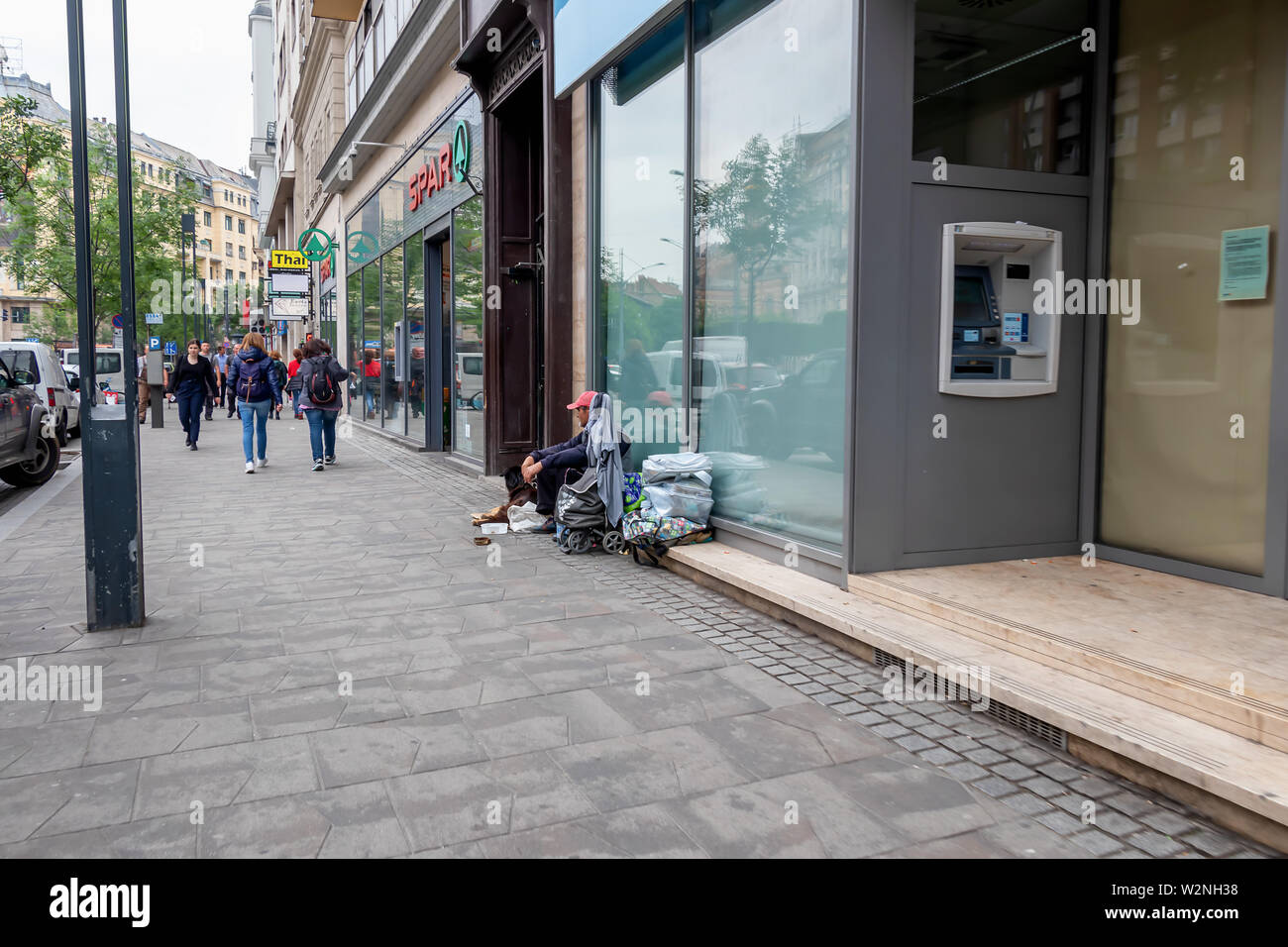 Budapest, Ungarn - 27. Mai 2019: Obdachlosen Mann mit Hund sitzend durch die Wand des Gebäudes auf der Straße von Budapest, Ungarn Stockfoto