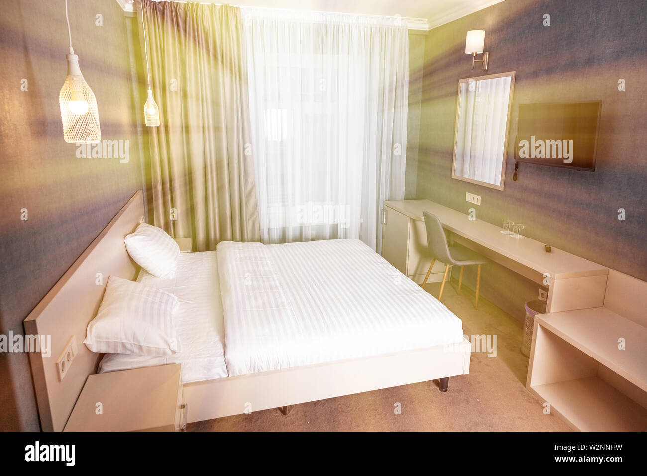 Komfortable Zimmer, mit TV, großer Spiegel, elegante Lampen. Stockfoto