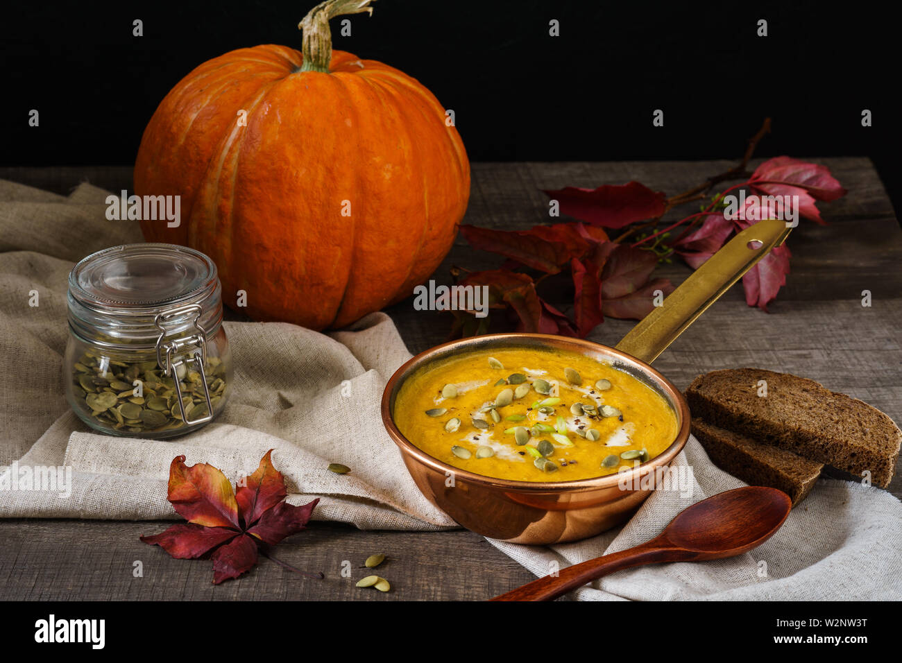 Kürbis Suppe in einer Kupfer Topf auf einem Holztisch. Herbst Mittagessen Konzept. Stockfoto