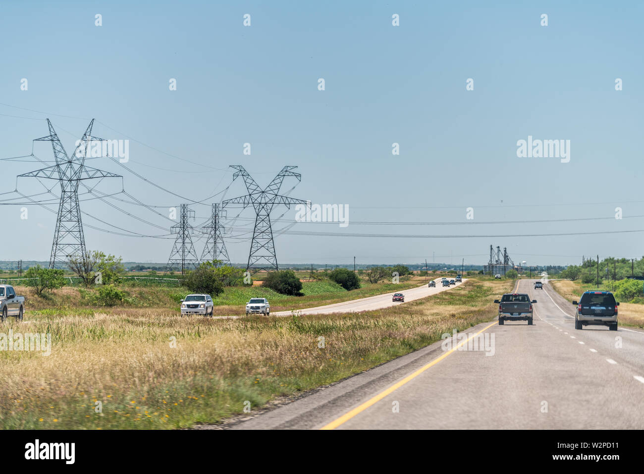 Hermleigh, USA - Juni 7, 2019: Autobahn Straße 84 in der Nähe von Snyder, Texas Landschaft mit Autos im Verkehr und Stromleitungen Kabel Stockfoto