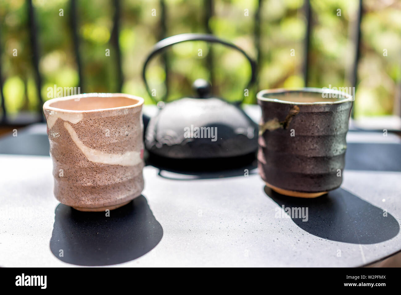 Gusseisen Teekanne auf Tisch draußen durch Zaun von Garten mit zwei Tassen  und Japanische Mino Kaffee Tassen am Morgen closeup Stockfotografie - Alamy