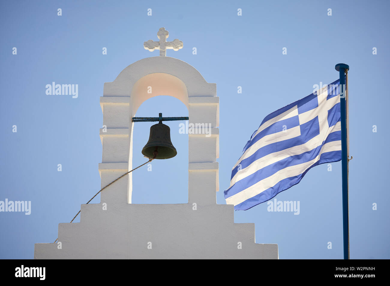 Mykonos, griechische Insel Mikonos, Teil der Kykladen, eine kleine Kirche und die griechische Flagge Stockfoto