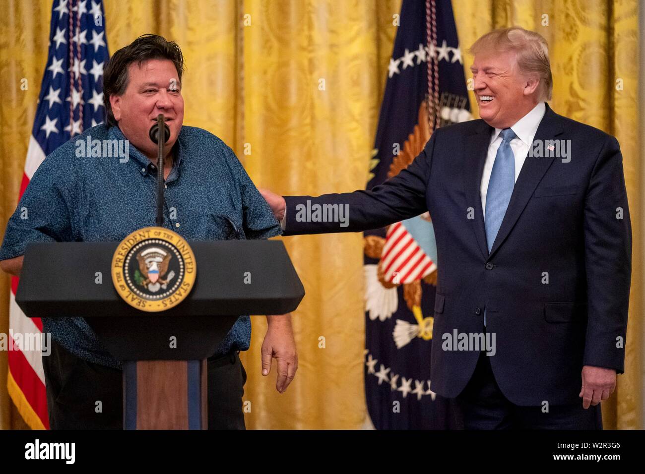 Us-Präsident Donald Trump lächelt wie Bruce Hrobak, Inhaber von Billy Bones Köder und Gerät einen Shout Out gibt in Unterstützung des Präsidenten im East Room des Weißen Hauses Juli 8, 2019 in Washington, DC. Der Präsident eine Ansprache über die Führung. Stockfoto