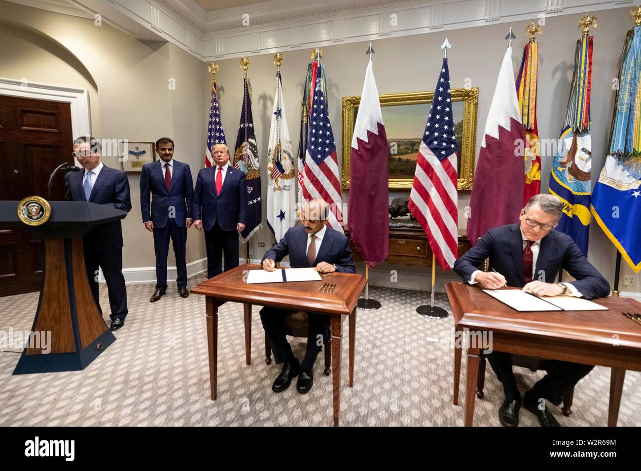 Us-Präsident Donald Trump, steht neben dem Emir von Katar, tamin Bin Hamad Al Thani, wie sie die Unterzeichnung einer kommerziellen Vereinbarung im Roosevelt Raum des Weißen Hauses Juli 9, 2019 in Washington, DC. Us-Finanzminister Steve Mnuchin, Links, Adressen der Delegation. Stockfoto