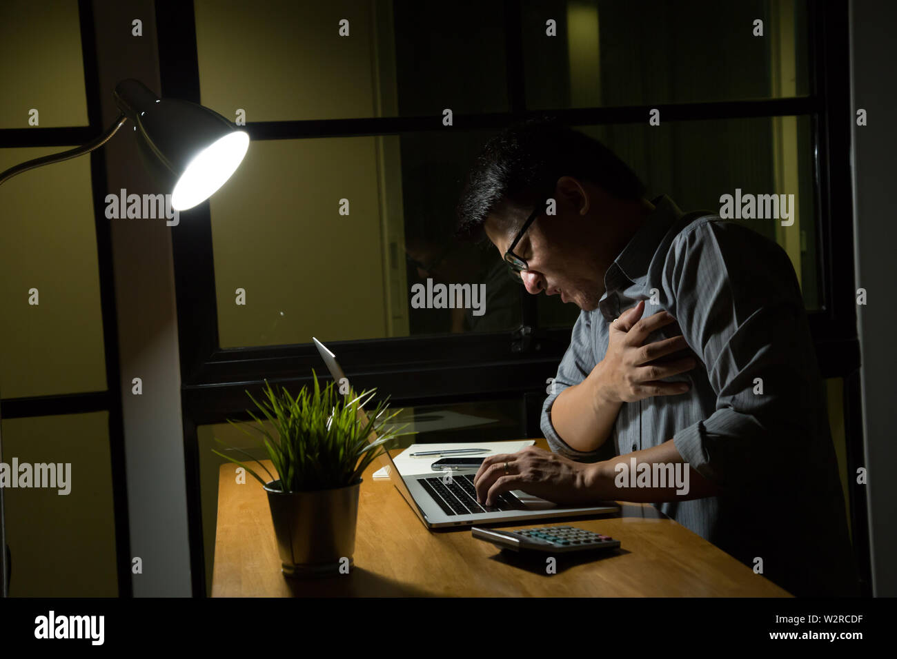 Symptome einer Krankheit während der Überstunden in der Nacht im Büro, zu spät und gesundes Konzept Stockfoto