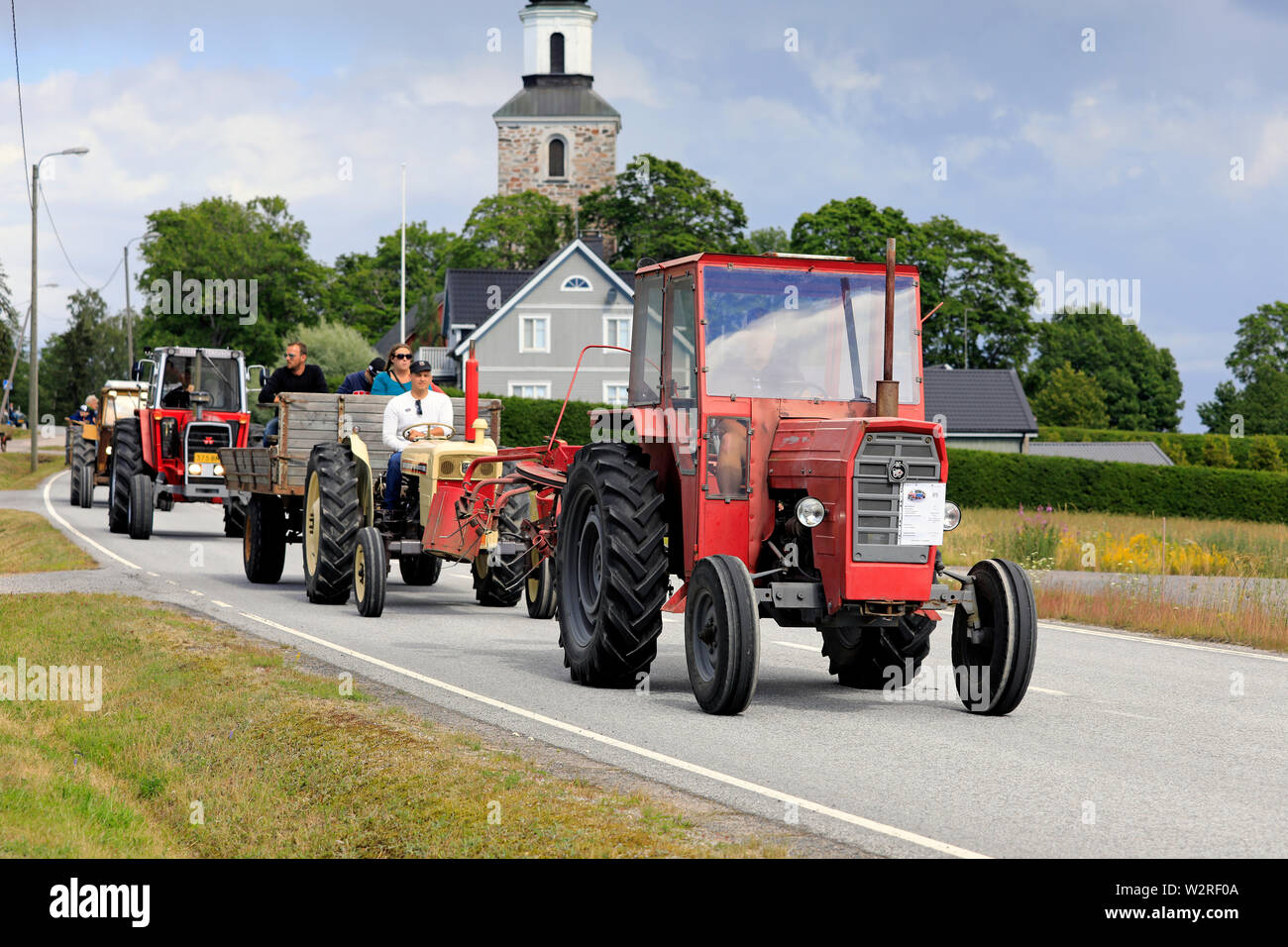 Kimito, Finnland. Juli 6,2019. Klassische Traktoren, rot IMT574 Erste, landwirtschaftliche Maschinen und Menschen genießen die Fahrt auf Kimito Traktorkavalkad Traktor Parade Stockfoto