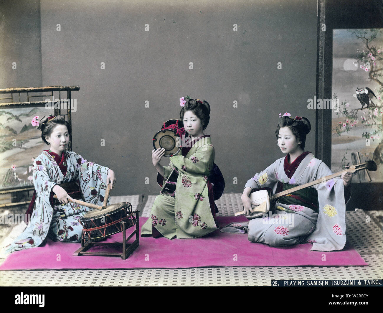 [1890s Japan - Maiko (Lehrling Geisha) Musik] - Maiko im Kimono und traditionellen Frisuren spielen tsutsumi (auch tsuzumi) Schulter Drums, shamisen, eine 3-saitige Musikinstrument und eine taiko Drum als ootsutsumi bekannt. 19 Vintage albumen Foto. Stockfoto