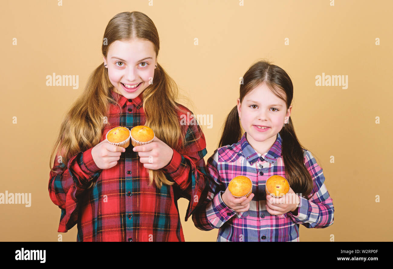 Muffin kämpfen. Kleine Kinder glücklich lächelnd mit quickbread Muffins. Glückliche kleine Mädchen backen Frühstück Muffins zu Hause. Genießen Sie Ihre bevorzugten muffin Flavour. Stockfoto
