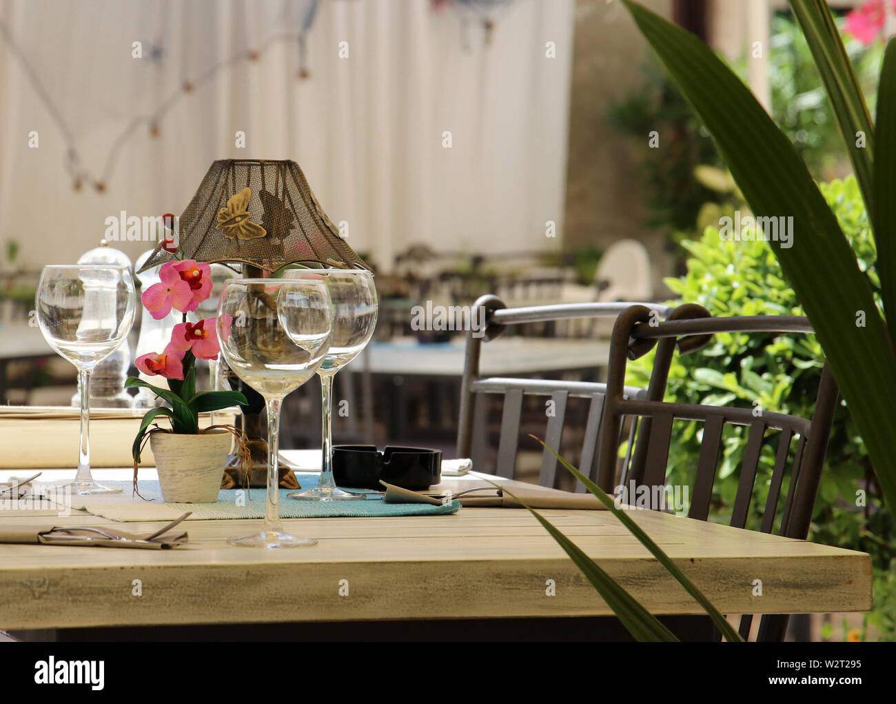 Weingläser auf einem Tisch für das Mittagessen im Freien gelegt Stockfoto