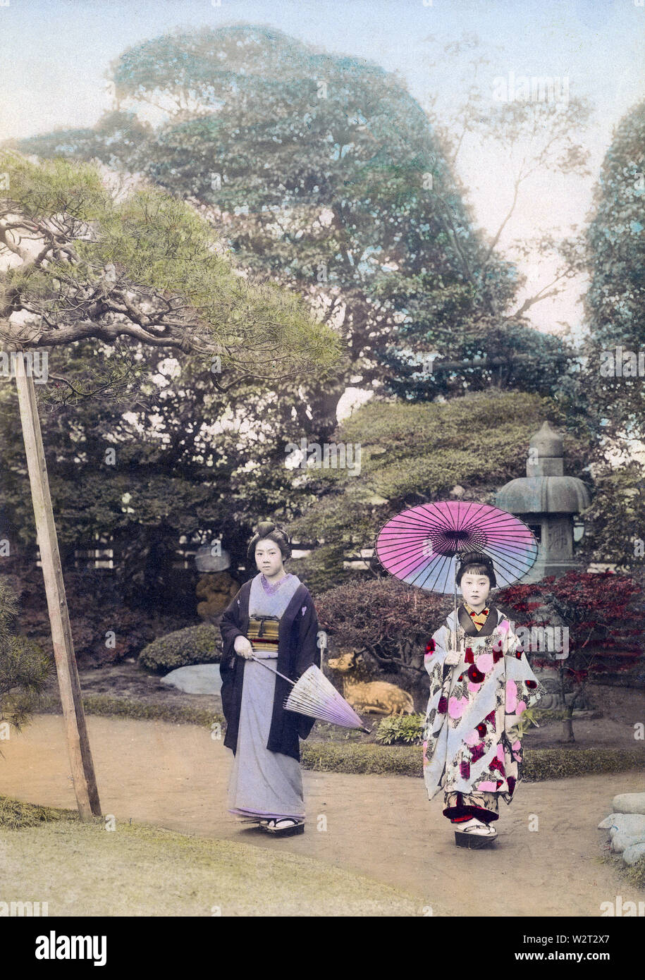 [1890s Japan - Japanische Frauen mit Sonnenschirmen] - zwei Frauen im Kimono holding Sonnenschirme in einem Japanischen Garten dar. In der Rückseite ein Stein Laterne gesehen werden kann. 19 Vintage albumen Foto. Stockfoto