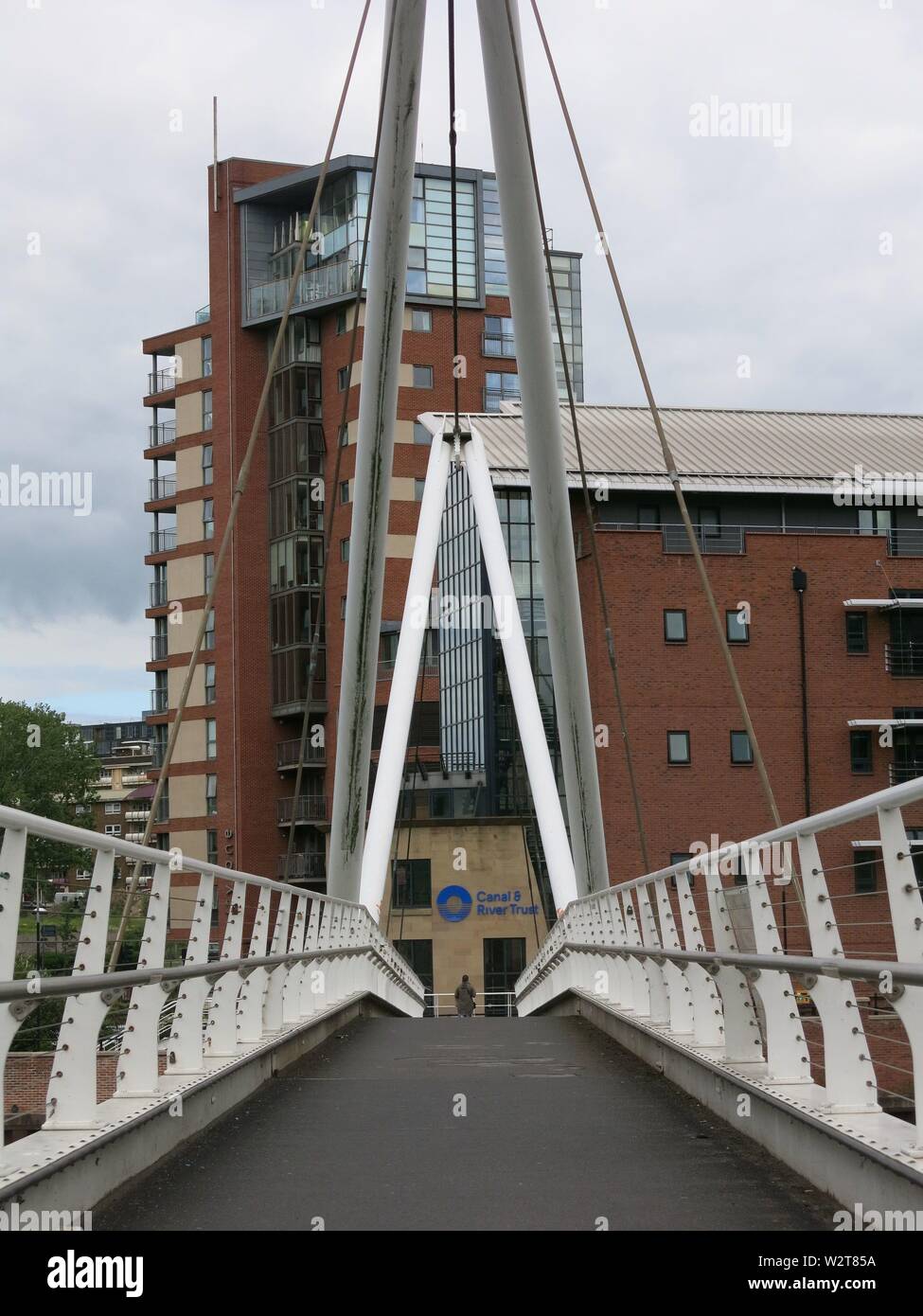 Anzeigen suchen entlang der Weise Fußgängerbrücke des Ritters über den Fluss Aire in Leeds Dock Stockfoto