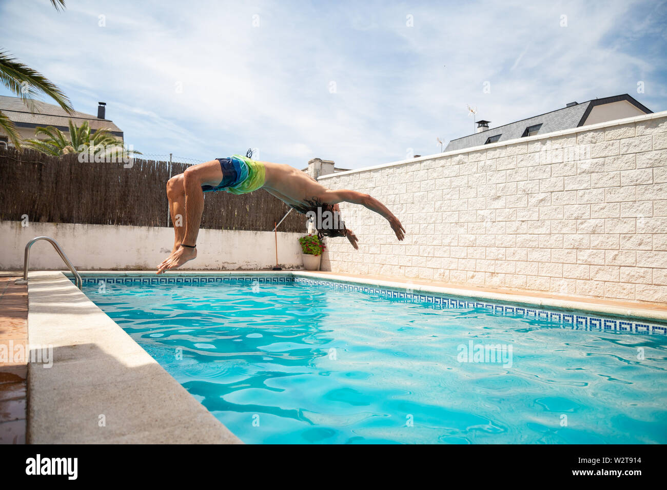 Junge fitness Mann in das Wasser im Pool ein Tag der Sommerferien springen Stockfoto