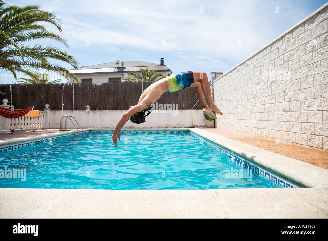 Junge fitness Mann in das Wasser im Pool ein Tag der Sommerferien springen Stockfoto