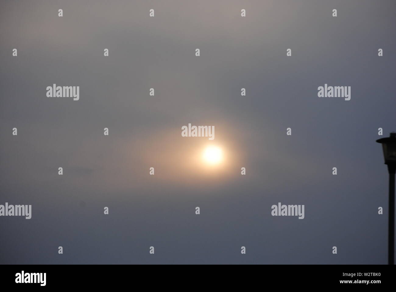Trübe Sonne durch dünne Wolke Stockfoto