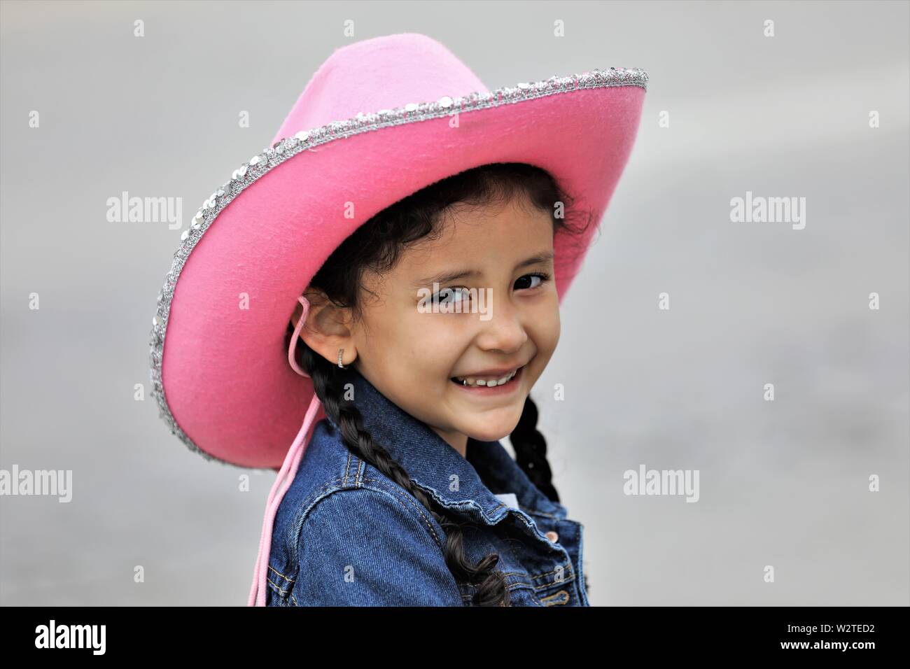 Echte 5 Jahre alten Hispanic Mädchen an cowboy Parade in Kalifornien mit rosa Hut und ein Lächeln Stockfoto