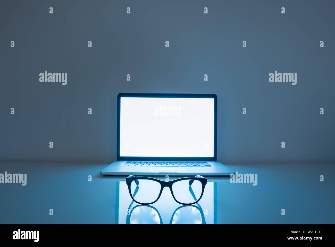 Computer Brillen vor einem Laptop, Low-key-Bild. Blaues Licht Blocker und Laptop in dunklen Hintergrund, Auge Müdigkeit problem Konzept Stockfoto