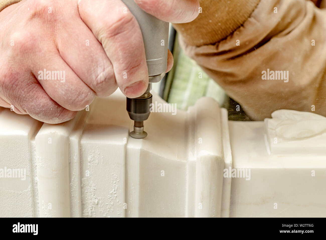 Closeup hand anonymer Handwerker mit elektrischen zu Gips Ornament in der Werkstatt zu schleifen Stockfoto