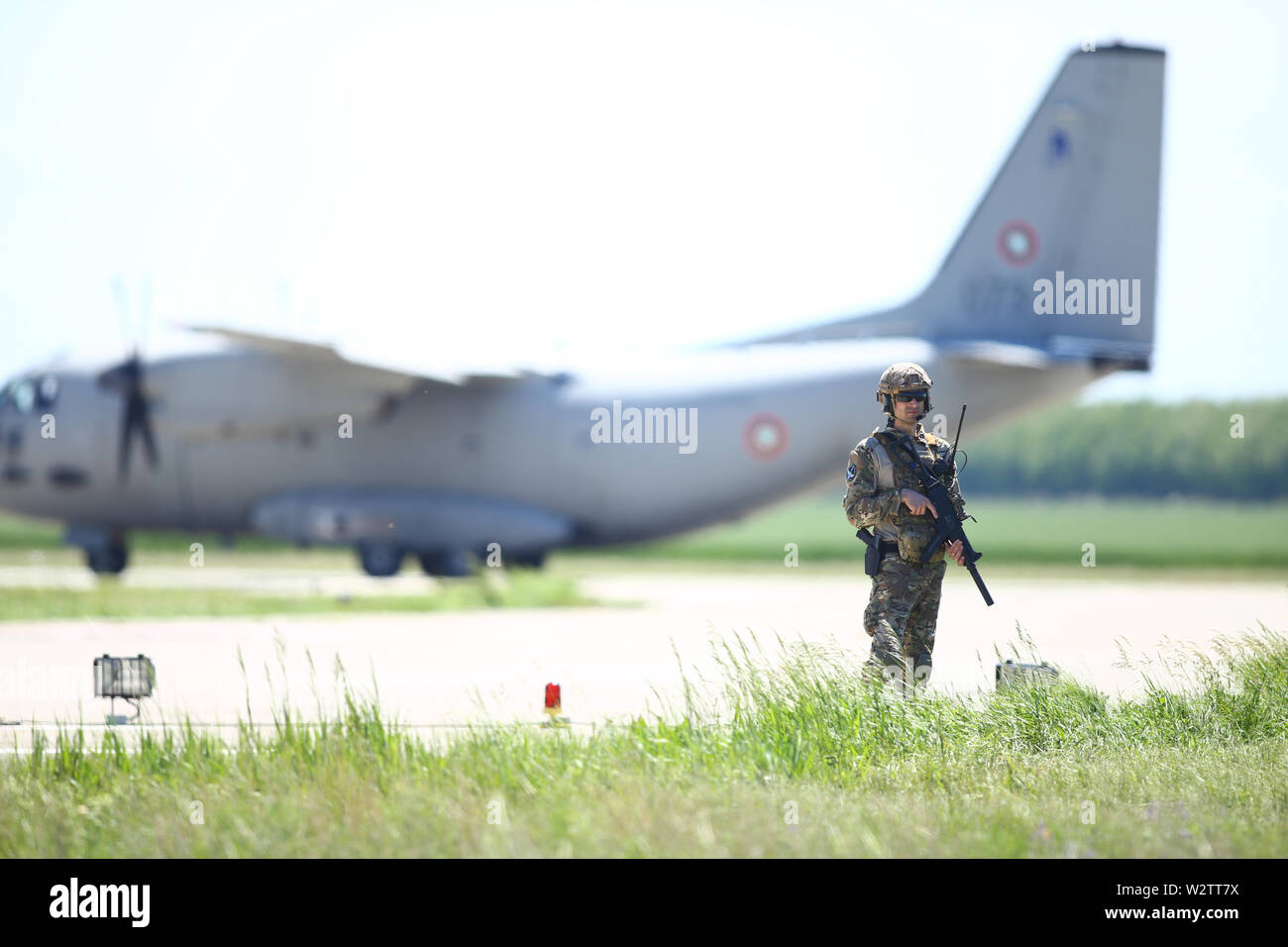 Boboc, Rumänien - 22. Mai 2019: Die rumänische Armee Soldat Patrouillen ein Military Air Base, mit einem Alenia C-27J Spartan militärischen Frachtflugzeug aus der Bulgarischen Stockfoto