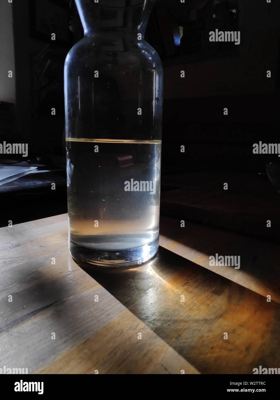 Flasche Trinkwasser auf Holztisch im Abendlicht Stockfoto