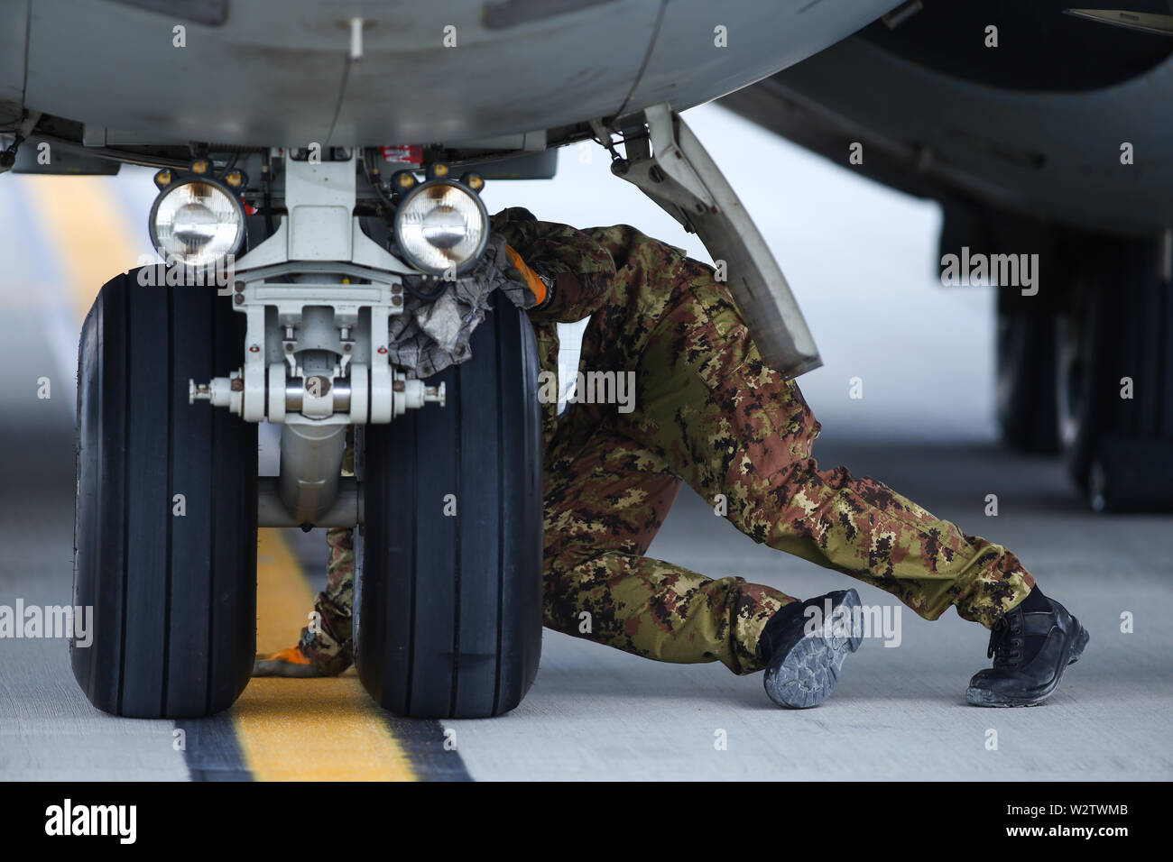 Otopeni, Rumänien - Mai 22, 2019: ein Mechaniker ist die Inspektion von Teilen eines Alenia C-27J Spartan militärischen Frachtflugzeug nach Landung auf einem Flugplatz. Stockfoto