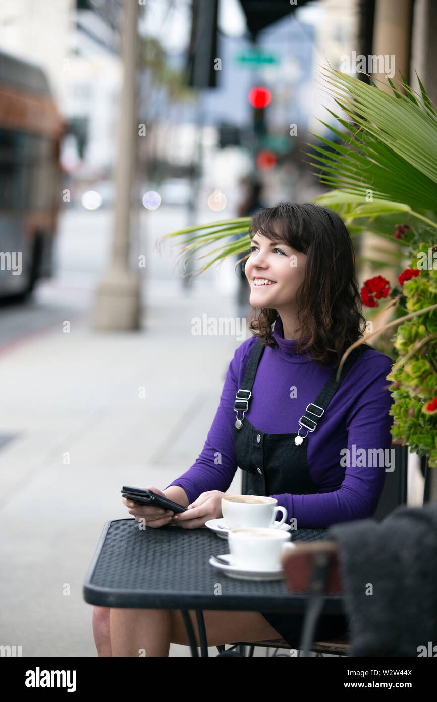 Frau eine Pause in einem Café oder lokalen Cafe in der Stadt und warten, um einen Freund zu treffen. Sie sitzen in einem Straßencafé Restaurant h Stockfoto