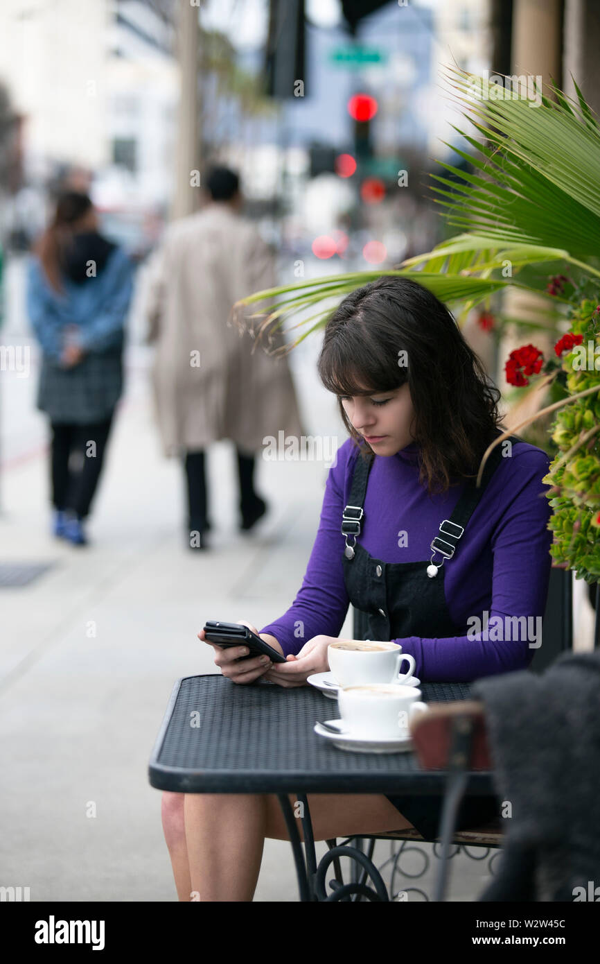 Frau eine Pause in einem Café oder lokalen Cafe in der Stadt und warten, um einen Freund zu treffen. Sie sitzen in einem Straßencafé Restaurant h Stockfoto