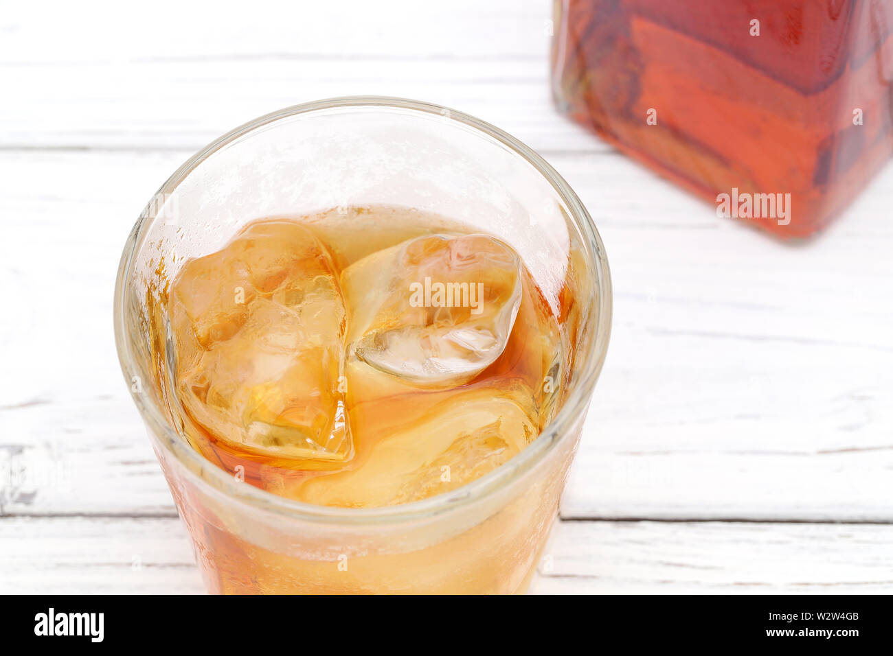 Glas Schale und eine Flasche Whiskey auf weißem Hintergrund Stockfoto