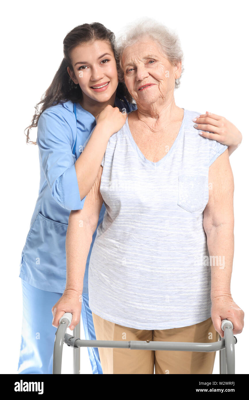 Junge Betreuer mit älteren Frau auf weißem Hintergrund Stockfoto