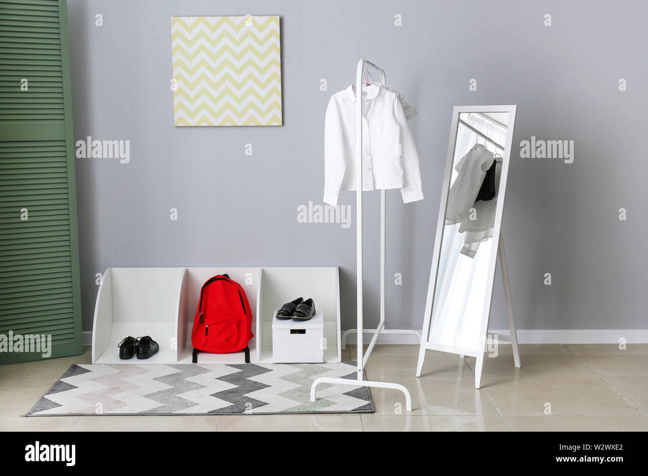 Stilvolle Schuluniform, Rucksack und Schuhe im Zimmer Stockfoto