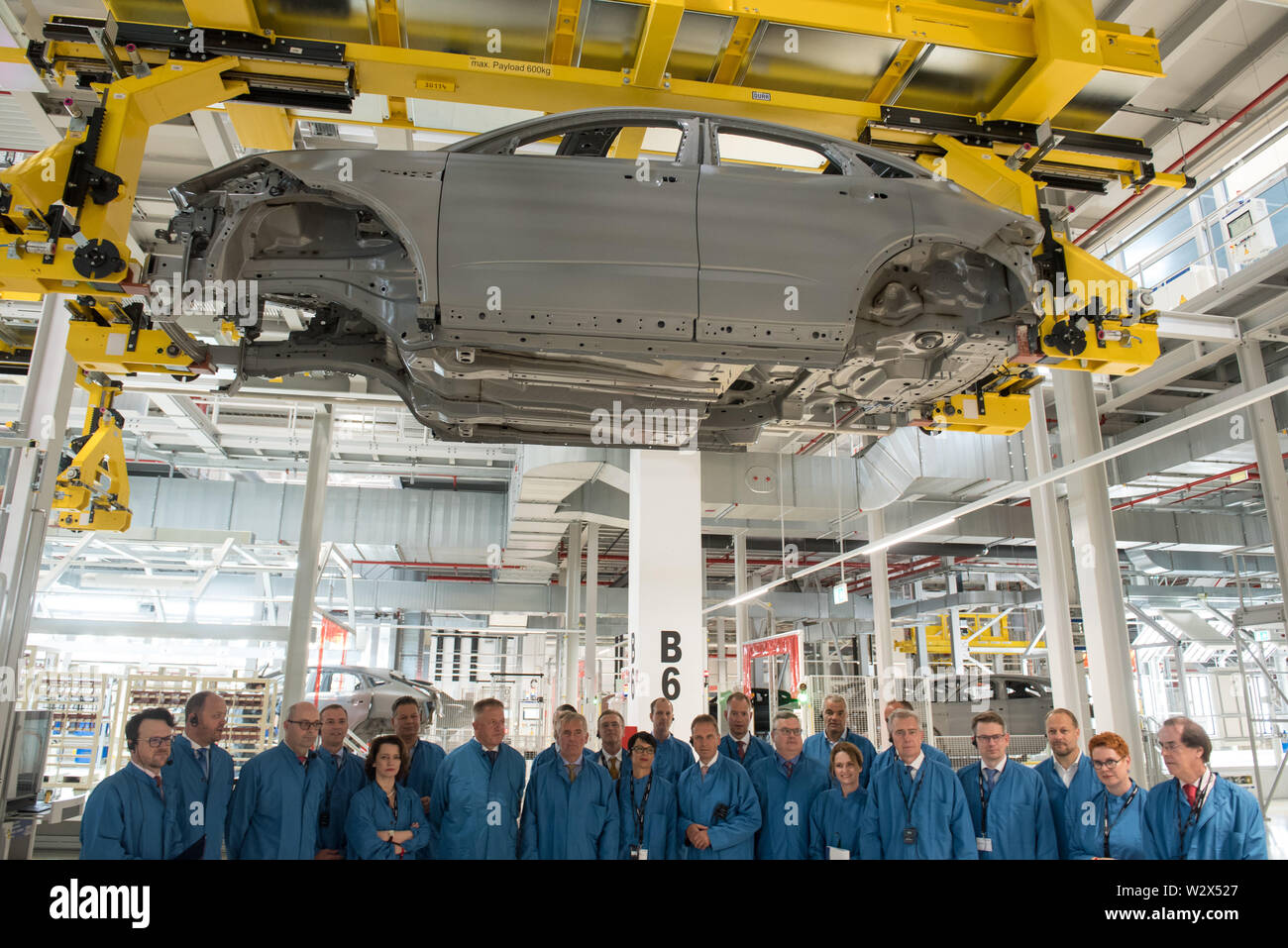 Hoøice, Slowenien. 10. Juli 2019. Besucher posieren für ein Gruppenfoto bei Magna Lackiererei Anlage unter einem Jaguar E-Space X540 des Körpers. Magna Steyr starten neue Lackiererei im Werk Hoøice, Slowenien. Magna ist einer der größten Automobilzulieferer der Welt. Neues Werk beschäftigt 200 Personen und in diesem Stadium sind sie Malerei Jaguar E-Space X540 stellen. Neue Lackierlinie wurde Graz Fahrzeug Produktion zu unterstützen. Credit: SOPA Images Limited/Alamy leben Nachrichten Stockfoto