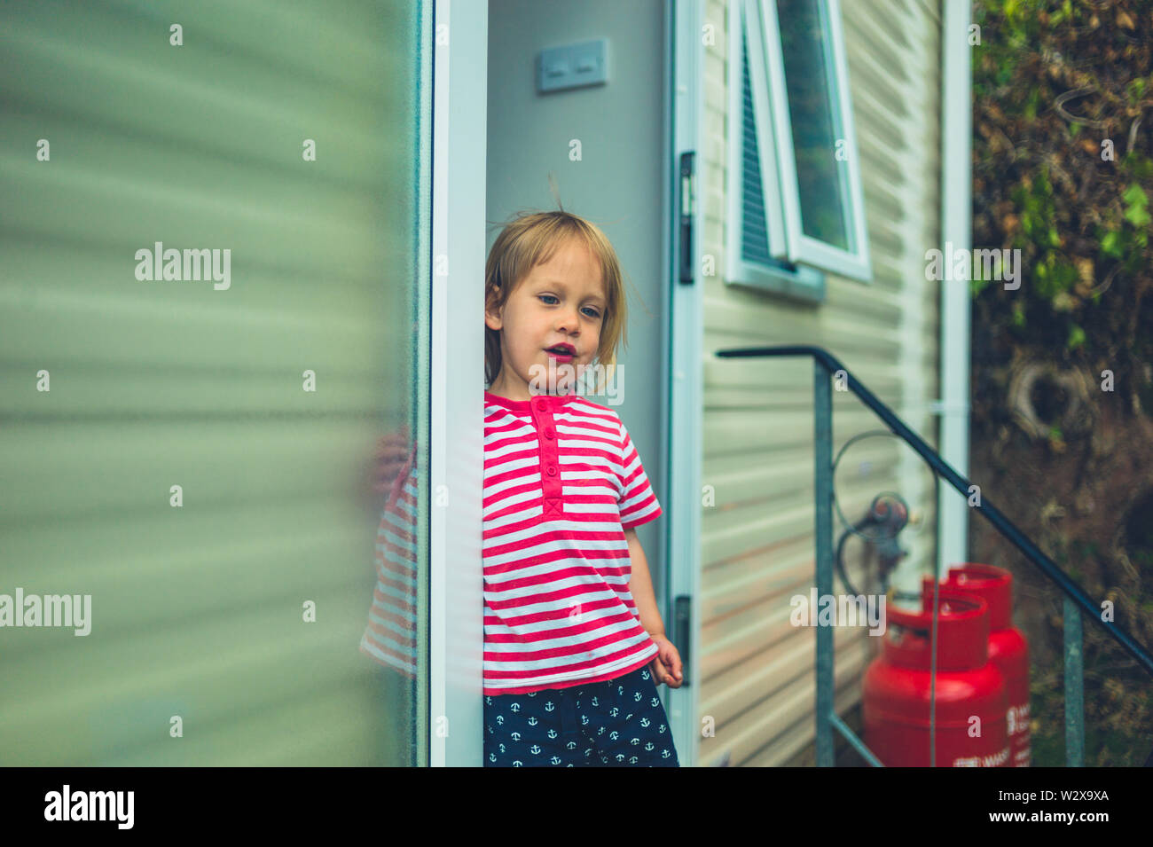 Ein kleines Kind steht in der Tür eines Anhängers Stockfoto
