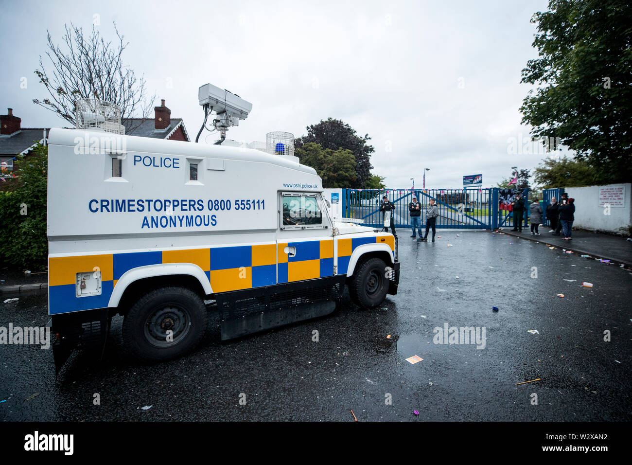 PSNI Offiziere escort eine Belfast City Council Arbeiter in der PSNI Fahrzeug heraus zu verlas eine Erklärung verlangt, dass die, die sich auf die Eigenschaft der Bereich Räumen bei Avoniel Leisure Centre, wo ein 11. Nacht Lagerfeuer errichtet wurde. Belfast City Rat bekräftigt seine Entscheidung gestern zum dritten Mal Materialien aus einem Lagerfeuer Website neben dem Zentrum zu entfernen. Stockfoto