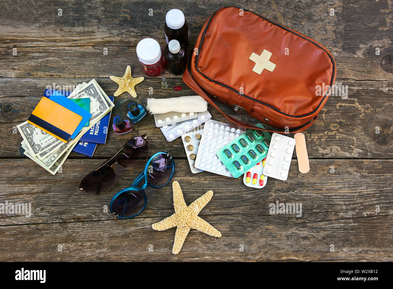 Sommer der Frauen Strand Zubehör für Ihr Meer Urlaub und Erste Hilfe Kit im alten Holz- Hintergrund. Konzept der Medikation in Reise erforderlich. Ansicht von oben. Stockfoto