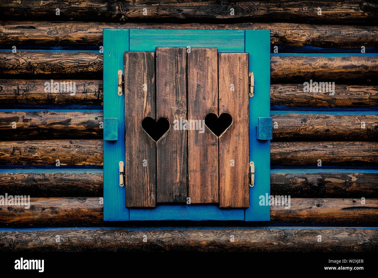 Architektur Detail - alte Fensterläden aus Holz mit geschnitzten Herzen. Stockfoto