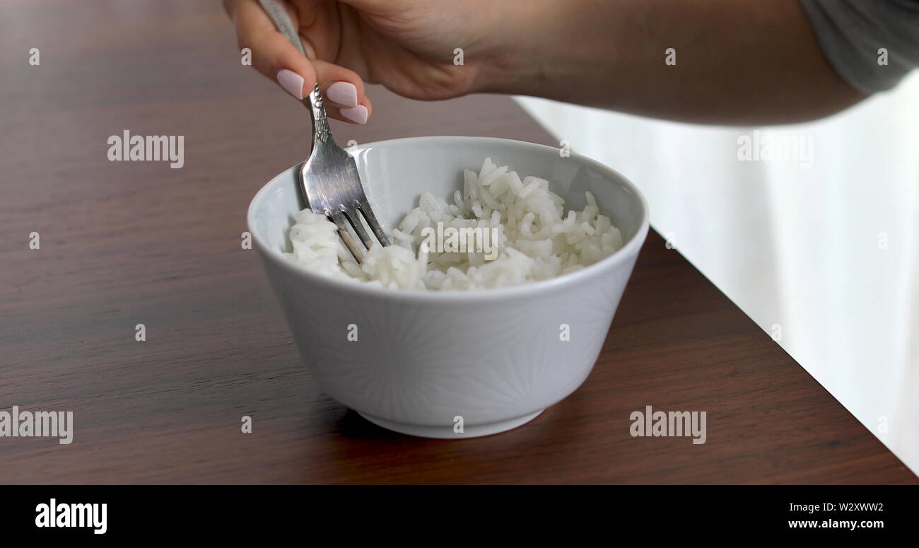 Nahaufnahme von Frau Reis essen aus dem Abscheidegefäß Stockfoto