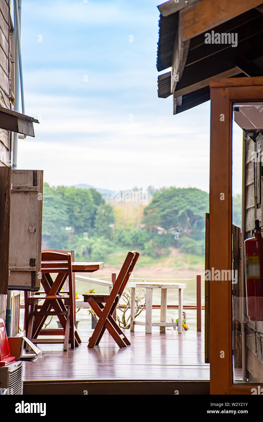 Hölzerne Stühle auf dem Balkon. Hintergrund auf dem Mekong und die Bäume an der Straße zu Fuß Chiang Khan, Loei in Thailand. Stockfoto