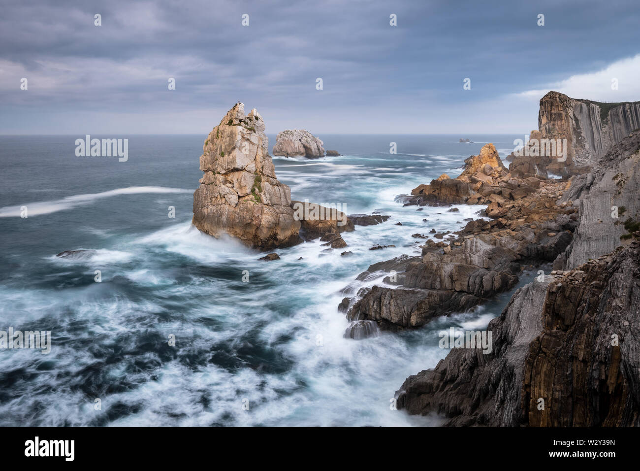 Felsen Urros von liencres und steilen Klippen in kochendem wilde Wellen bei Sonnenuntergang, Costa Quebrada, Kantabrien, Nordspanien Stockfoto