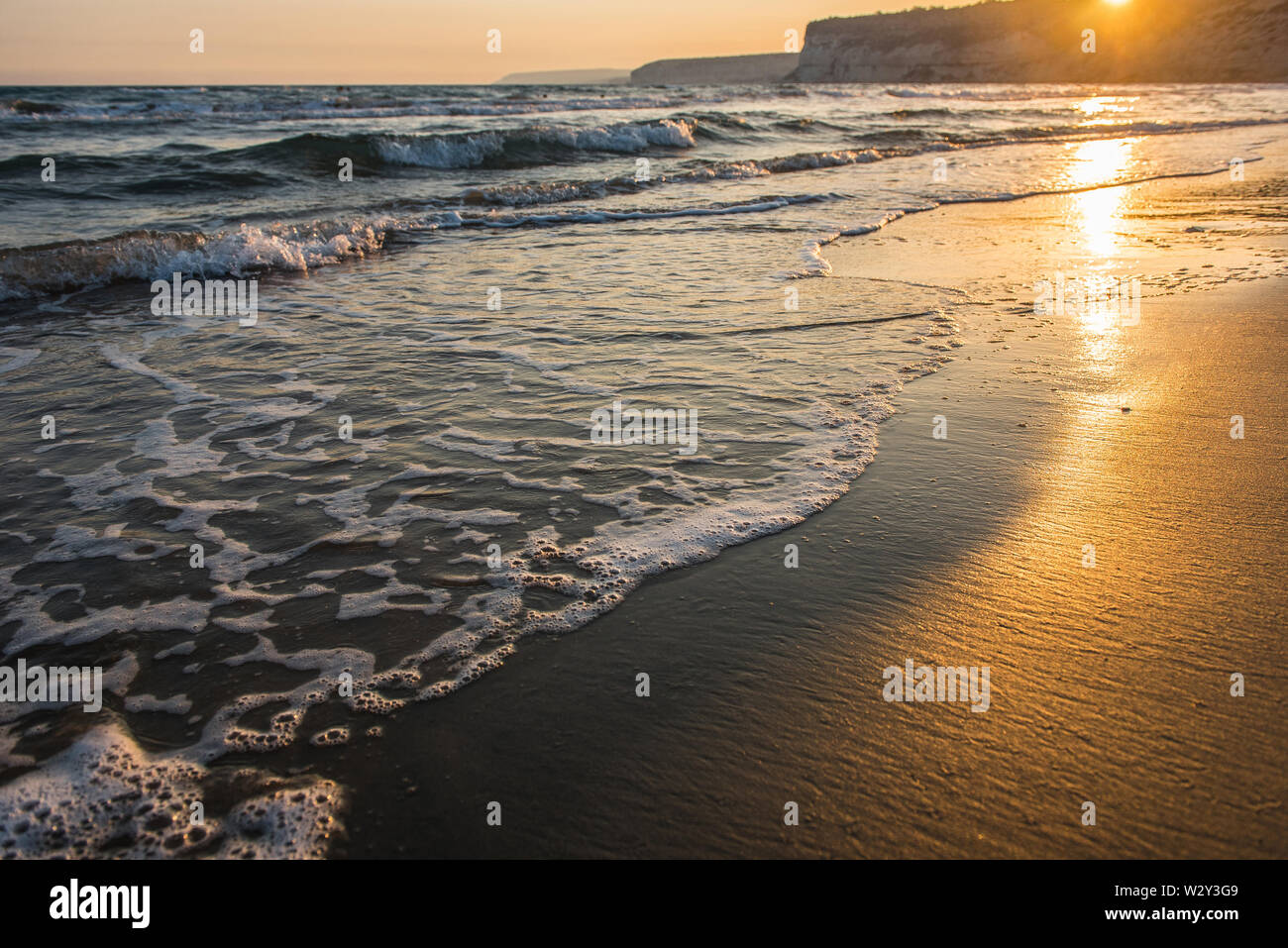 Meer Wellen waschen Sandstrand im Sonnenuntergang Stockfoto