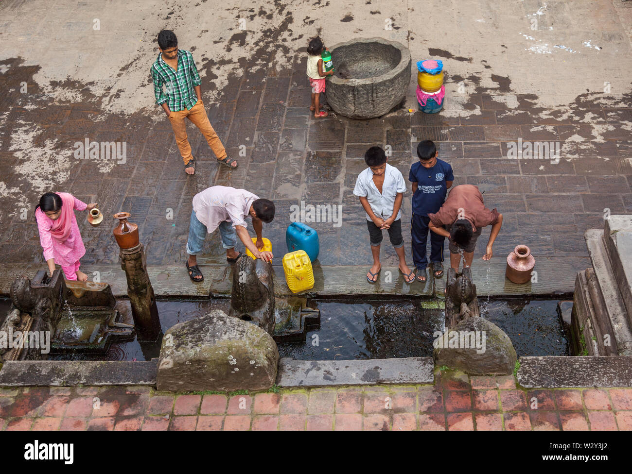 Die Menschen vor Ort sammeln von Wasser aus einer Quelle in Kathmandu. Stockfoto
