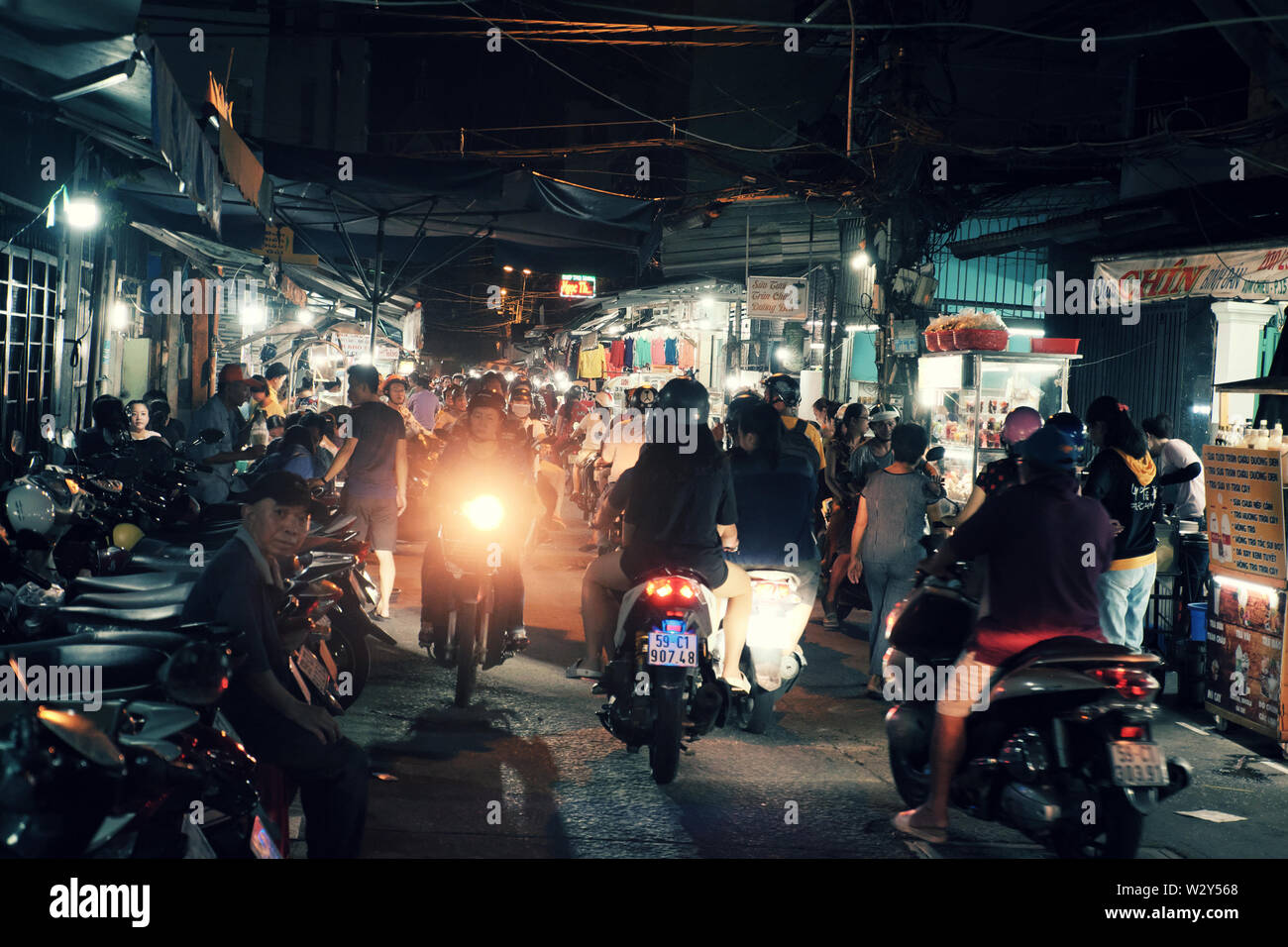 Geschäftige Atmosphäre auf Food Street wenn Leute gehen, mit dem Motorrad im Abendessen Zeit für das Essen im Restaurant im Freien, Nacht, Vietnam Stockfoto