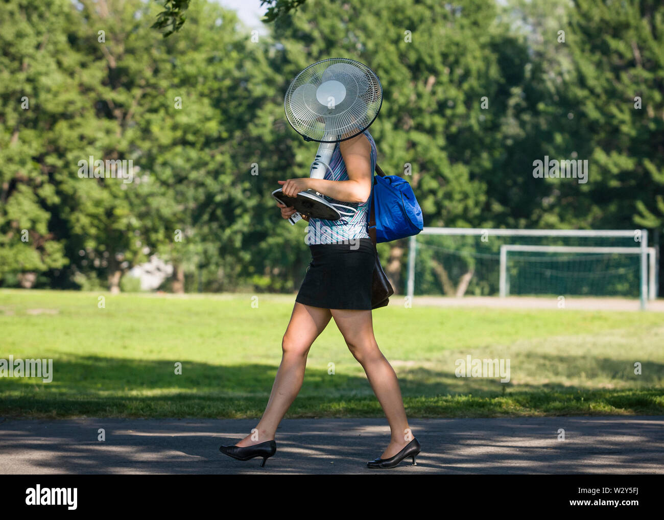 Eine Frau trägt ein Fan, wie sie durch Jeanne-Mance Park Spaziergänge in Montreal, Kanada während der sommerhitze am Donnerstag, 8. Juli 2010. Stockfoto